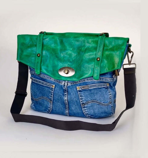 Stylish green leather and denim handbag with dual pockets and adjustable strap.